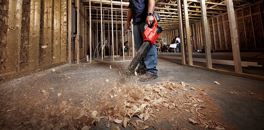 Someone cleaning debris off a jobsite with a Milwaukee Blower