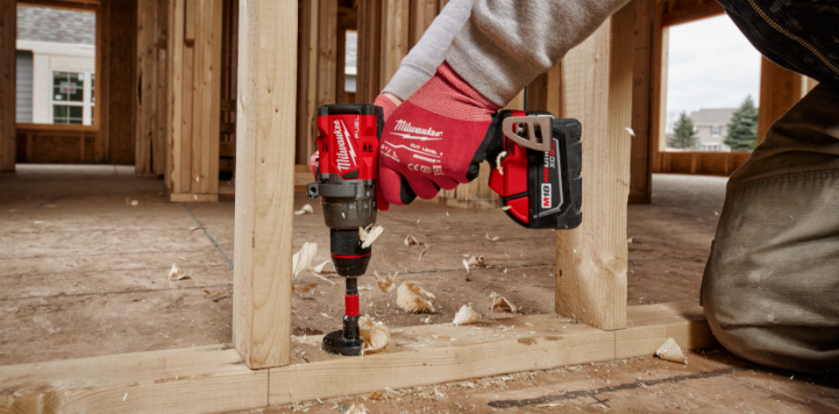 Construction worker drilling into wood with the Milwaukee M18 Fuel 1/2" Hammer Drill, 2904-20.