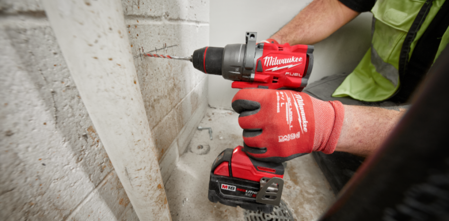 Construction worker drilling a hole into concrete with a Milwaukee M18 Fuel 1/2" Hammer Drill, 2904-20.