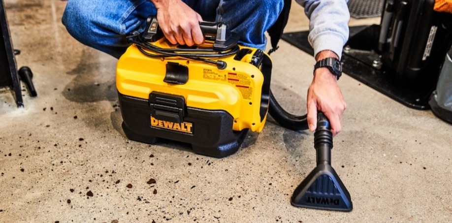 Someone using a Dewalt 20V Vacuum to clean a mess on the floor