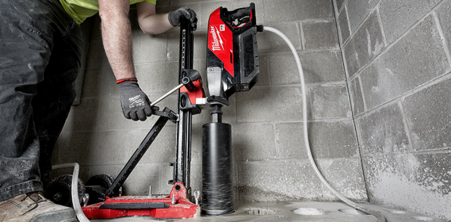 A picture of someone using a core drill to drill holes in concrete