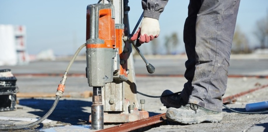 A picture of someone using a core drill on a construction site