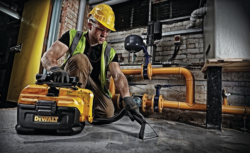 Someone using the Dewalt 20V Vacuum to clean a water spill