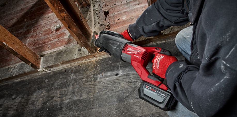 A person cutting through wood with a Milwaukee M18 Sawzall