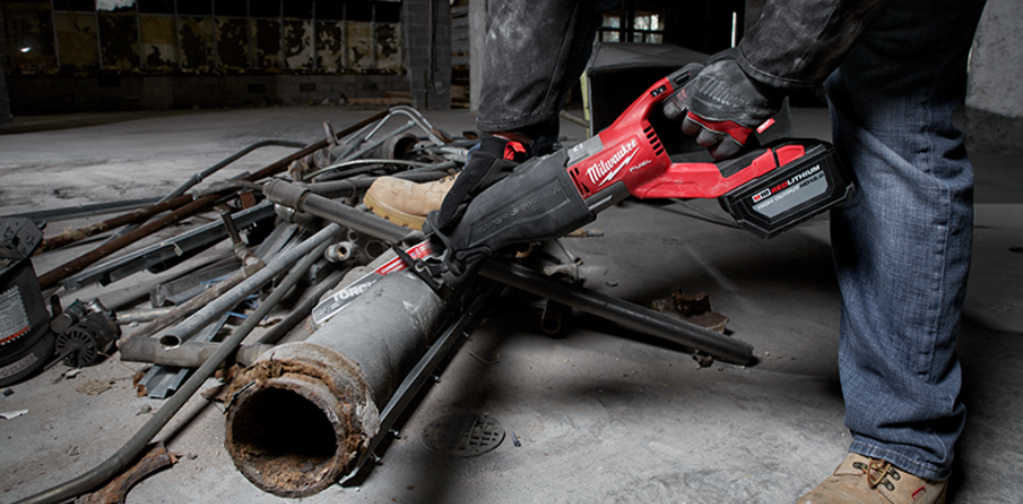 Someone cutting through a piece of pipe with a Milwaukee Sawzall.