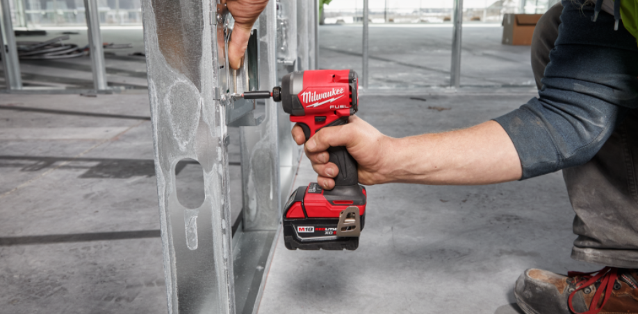 A picture of a impact driver driving a screw into a piece of metal