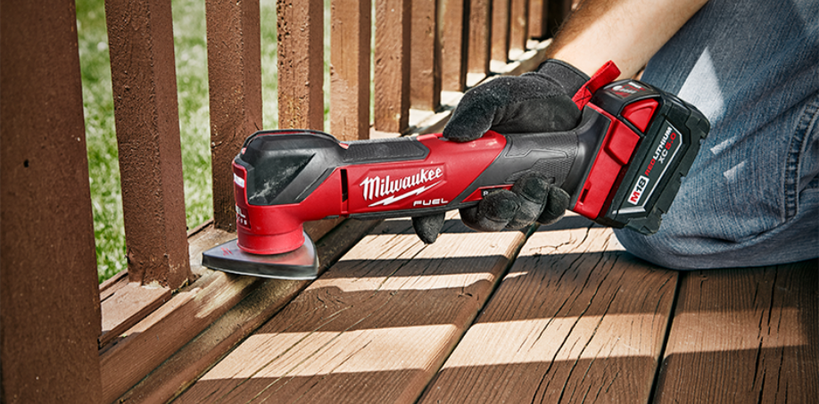 Someone using a Milwaukee M18 multi-tool to sand wood